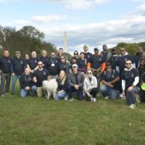 A group of people posed outside. The Washington Monument in the distance.