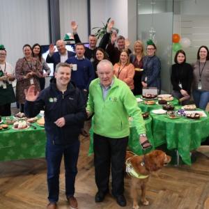 A room full of people, tables with food on them.