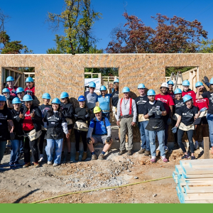 A group of volunteers outside a home being built