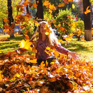 person playing in a pile of leaves