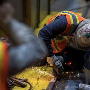worker in safety gear using an angle grinder