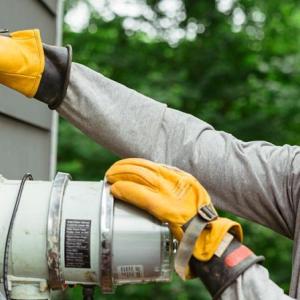Harrison Cochran working on an electrical box, wearing protective gear.