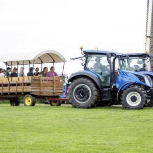 A blue tractor pulling people in a wagon
