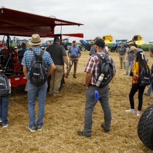 people in a field with tractors