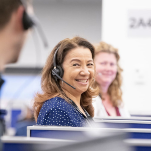 People wearing headsets smiling at each other 