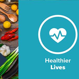 "Healthier lives" and logo. On the side a board of utensils, lobster, garlic and other produce.
