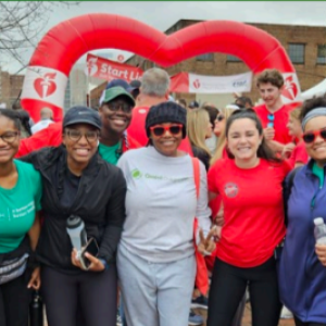 A group posed outside, a heart shaped balloon in the background.