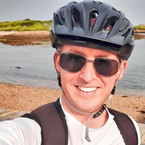 A person in a bike helmet and sunglasses