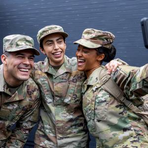 Three veterans with their arms around each other taking a photo