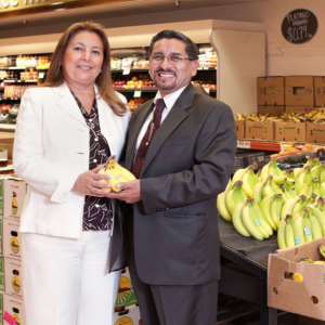 two people standing in the grocery store holding plantains