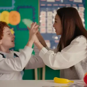 A child and a teacher high-fiving 