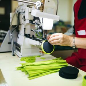 Worker in a factory sewing on a zipper
