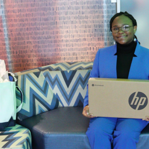 Person on couch holding HP Box