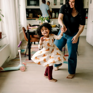 Parent twirling a little child around their dinning room