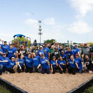 A large group photo in front of a playground 