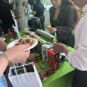 Various foods shown at a table, with three people standing next to it