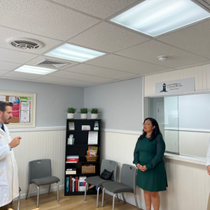 A doctor speaking to two others in the reception room of HOPE clinic.