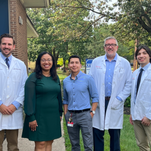 Group posed outside, some in medical coats.