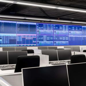 A call center with multiple digital screens at the front.