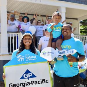 team standing in front of house