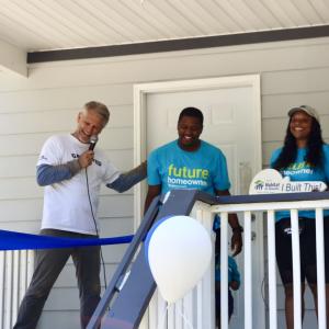 team standing in front of house