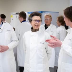 HRH Anne wearing a lab coat.