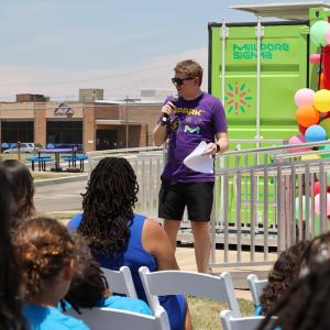 Jeffrey Whitford speaking to an audience in front of the Curiosity Cube.