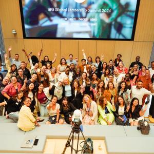 A group posed together in front of a digital display.