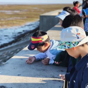 Children in China looking at ocean by a sea wall.
