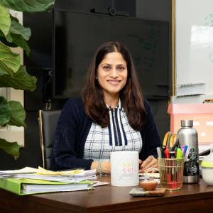 Ridhi Tariyal seated at a desk smiling.
