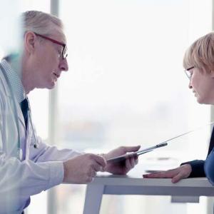 Doctor seated and consulting with a patient.