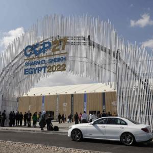 People walking in front of COP27 arch
