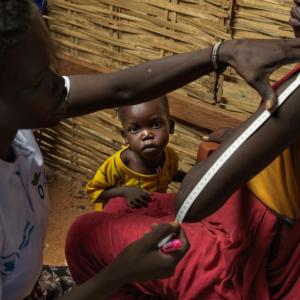 Adheet Akeen Alhia, 20, and her child are screened for malnutrition by Action Against Hunger staff after arriving at the South Sudan border point in Majok Yinthiou.  