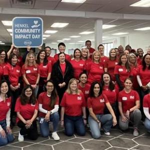 A large group of volunteers posed in an office setting.