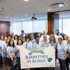 A group of volunteers posed with a sign "Alkermes in Action".