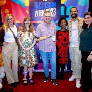 Six people posed, arms around each other. Balloons and "Inclusion Week 2023" behind them.