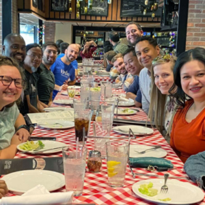 a group of about a dozen people sitting across from each other in a restaurant setting