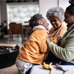 Two adults and a child smiling 