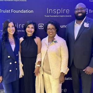 Four people standing in front of a blue screen with Truist foundation and Inspire logos.