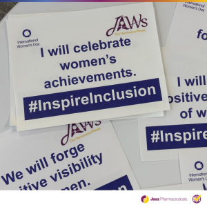 Papers on a table "I will celebrate women's achievements. #inspireinclusion".