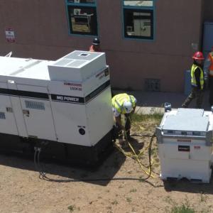 an outdoor generator being installed by a small team
