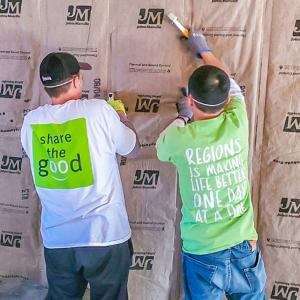 Two people install insulation 