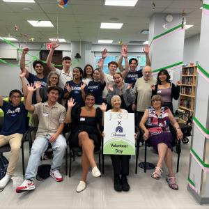 Paramount interns and an elderly woman holding a "Volunteer Day" sign
