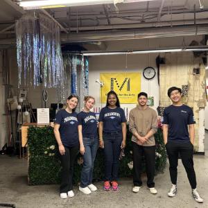 five volunteers in a decorated, industrial environment