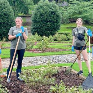 A group of volunteers posed with garden tools.