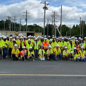 A group on high-vis vests and hard hats posed outside.