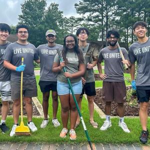 A group of volunteers posed with garden tools.