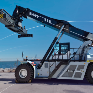 Side view of a fully electric SANY SRSC45E3 Reach Stacker at DP World’s Lirquén port terminal with ocean in background.