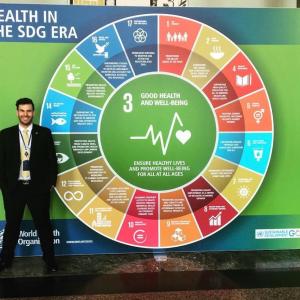 James Pfitzer stood next to a 'Health in the SDG era' board