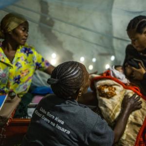 Janet works with Elilumba to show her proper breastfeeding techniques.